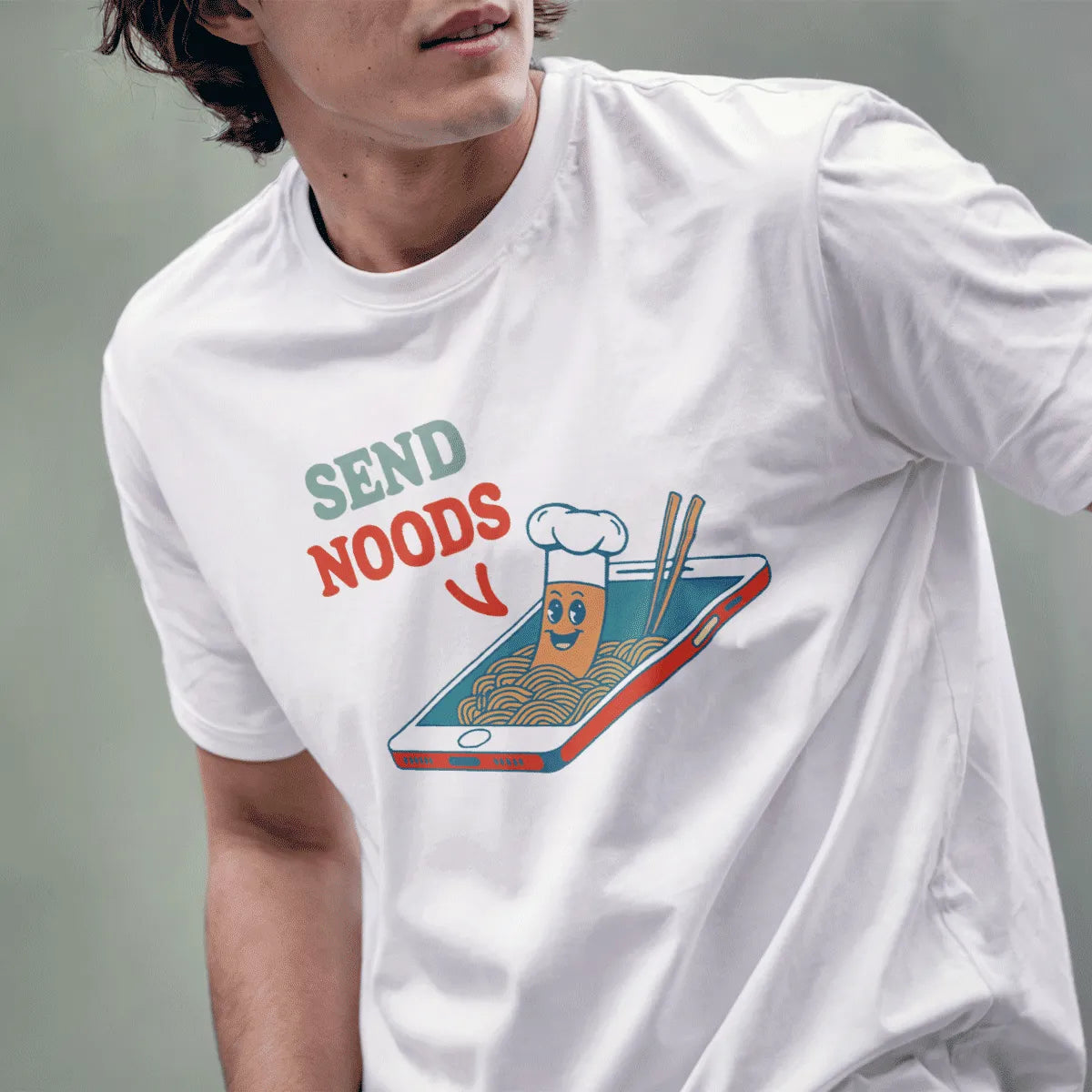 Male model in white t-shirt featuring “SEND NOODS” cartoon noodle with chef hat, ramen t-shirt, pop art shirt.