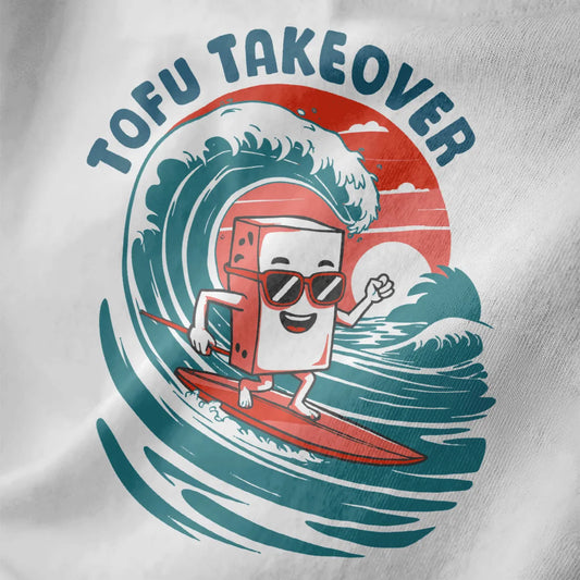 Close-up of playful tofu surfing design on white shirt, featuring bold “TOFU TAKEOVER” text and wave patterns.