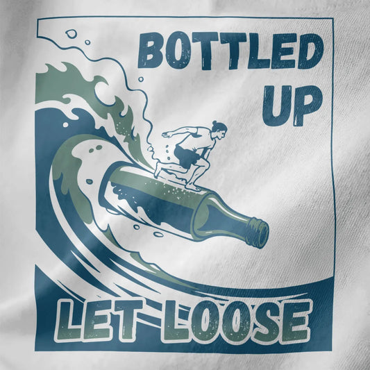 Close-up of white t-shirt fabric with bottle surfboard riding ocean wave, bold distressed "Bottled Up" text.