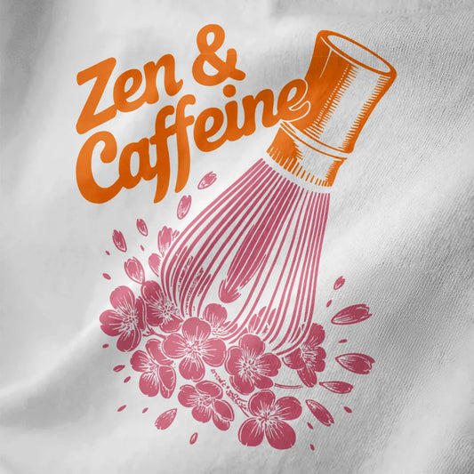 White shirt close-up showing "Zen & Caffeine" in orange playful script, matcha chasen, and pink cherry blossoms.